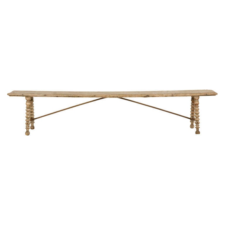 Antique Spanish bench.  Weathered wood finish.  Hand turned legs.  Wrought iron support detail.