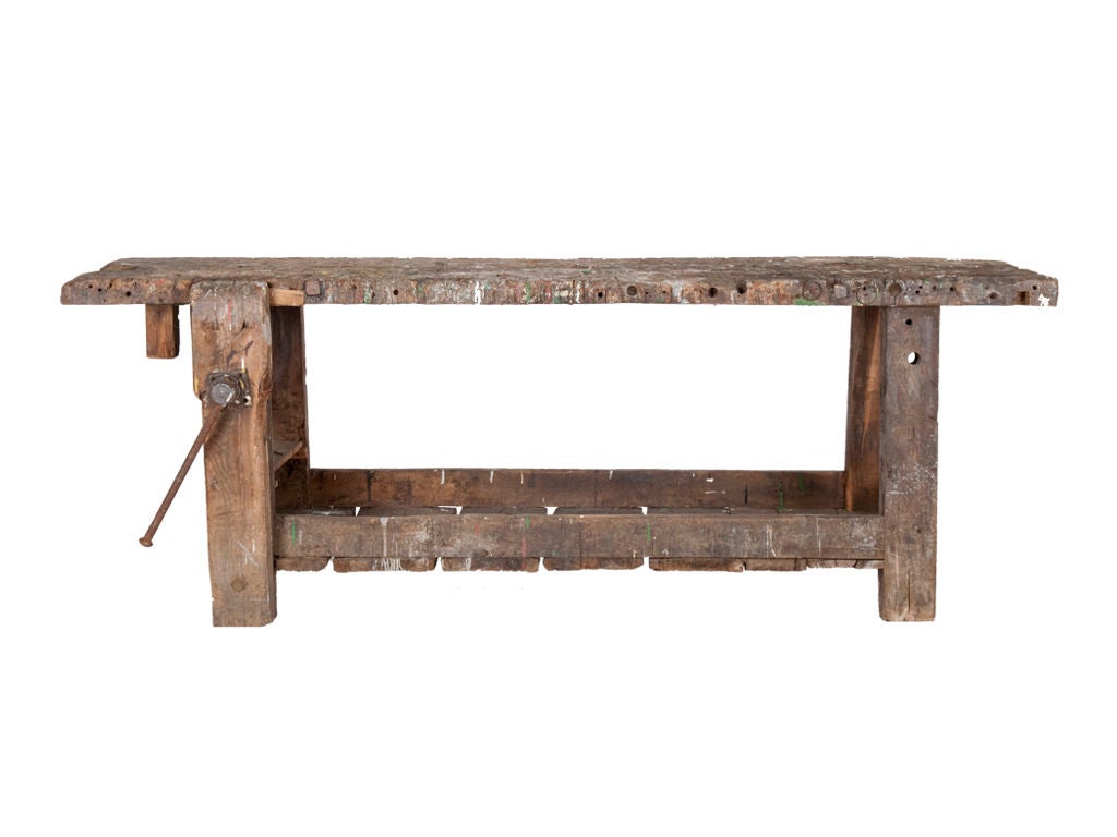 Hand hewed wood work bench with charming original paint splatters as found. Iron vise attached.