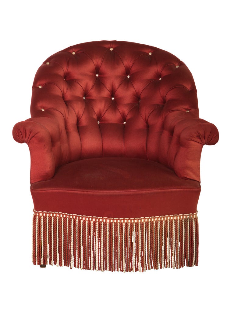 antique tufted chair. red fabric upholstery and fringe as found. set of two available (priced individually).