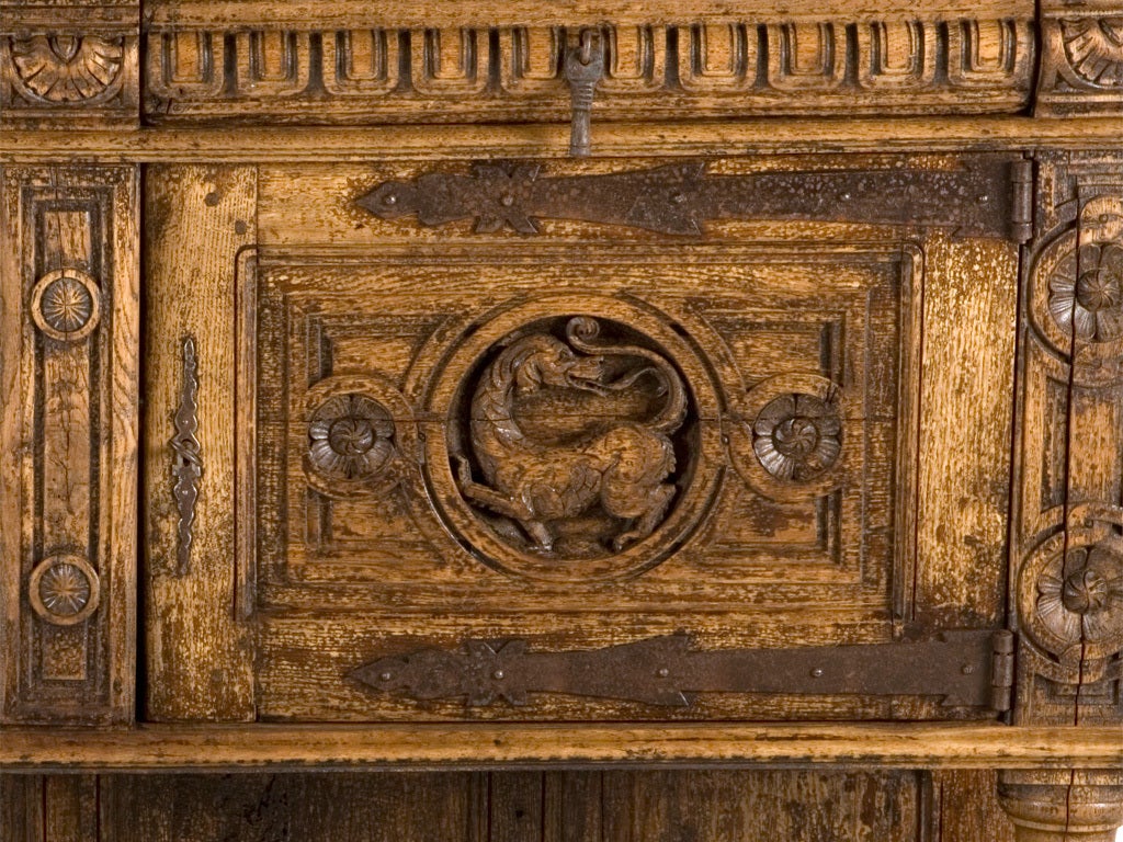 antique sideboard. hand carved details. stripped oak wood finish. wrought iron details.
