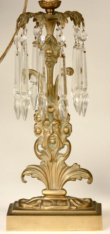 This pair of beautiful lamps features heavy cast brass bases that seem to be Neptune rising from the waves, each highlighted by elegant crystals hanging from an acanthus leaf bobeche. They may be used with candles or, to provide more light, simply