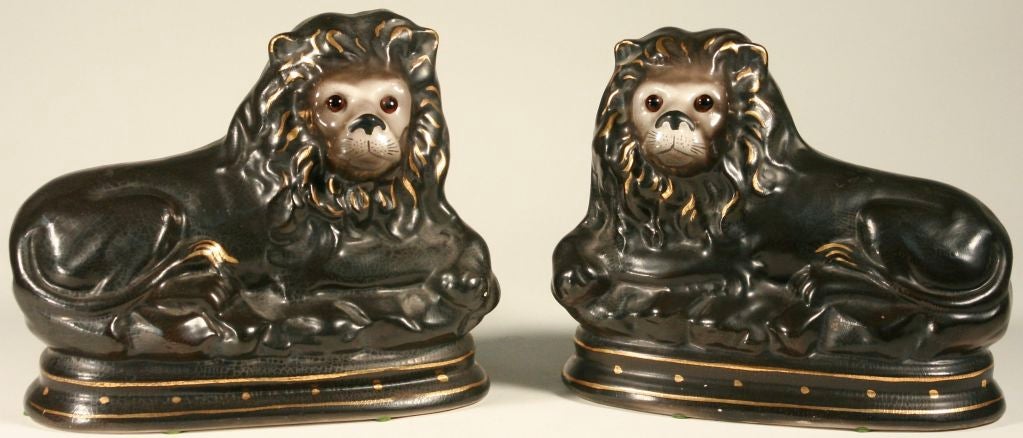 Beautiful pair of recumbent lions in a rather rare grey glaze, with gold accents and glass eyes. Staffordshire, England. Please Note: Not all items are actually in this location at any given time. If you're in San Francisco and would like to see a