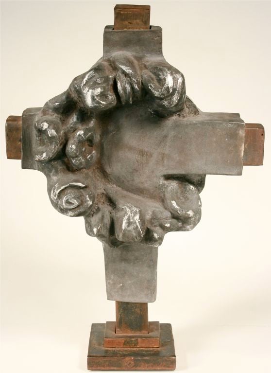 This powerful sculpture was created by sculptor Jan Barboglio, whose upbringing in Mexico informs her design motifs. Hand forged in Mexico, the piece consists of a solid iron cross encased in an outer shell of lighter metal incorporating an almost