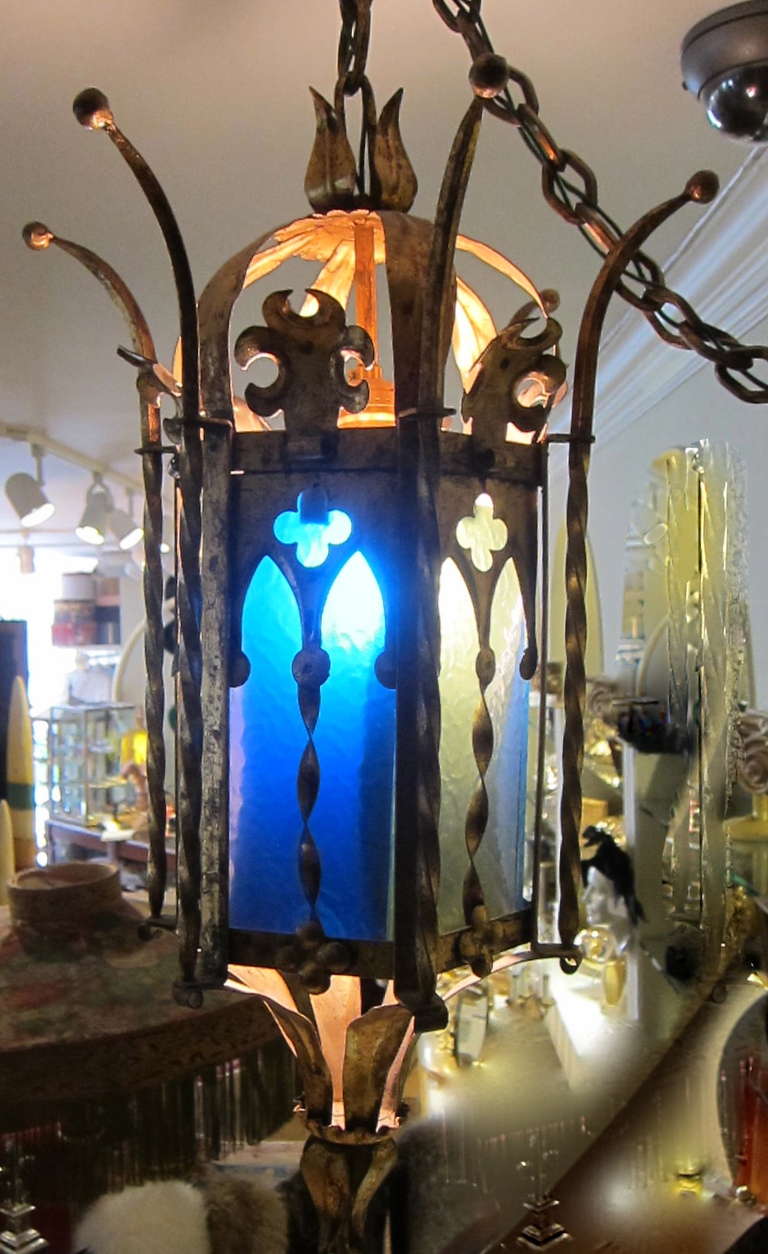 Delightful Hollywood Regency Mid Century Cathedral and kings crown motif. Muted gold tone metal. Blue and Green Glass panels. Super long chain swag. 
(measurement provided upon request) It has been gracing our boutique for a long time and now time
