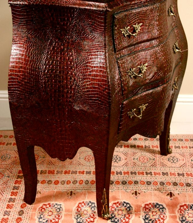 Beautiful pair of leather-covered bombe' chests, fully covered in a deep purplish-burgundy faux crocodile pattern. Buy separately or as a pair. The embossing is deep relief: very tactile. The chests appear to be considerably older than the covering.