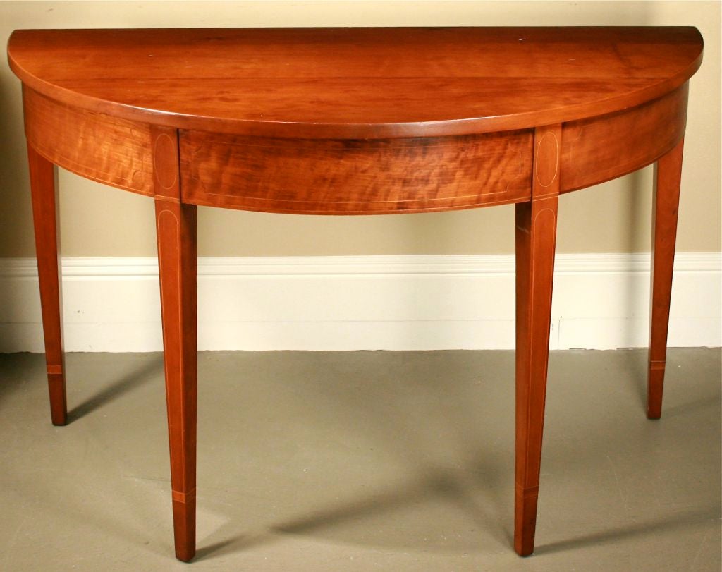 Offered is an elegant demi-lune table with tapered legs and inlaid banding. <br />
<br />
Keywords: table, console, demilune, halfmoon, half moon, hall, hallway, entrance, entranceway, refined,