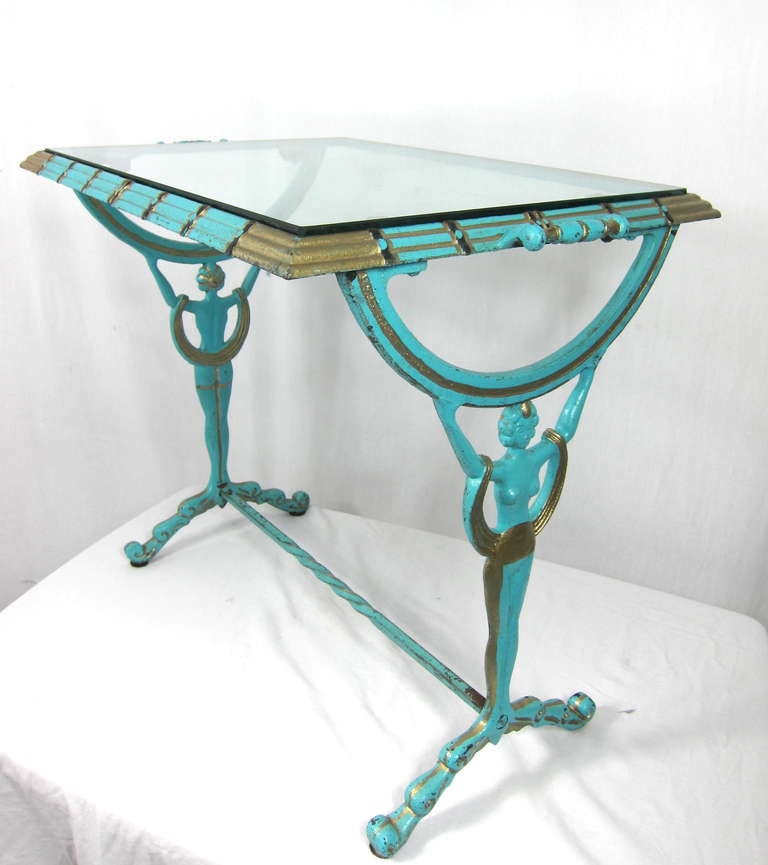 THIS IS A FUN SIDE TABLE. IT IS FROM THE 1930's and is  a solid metal painted (probably not the original paint) .It is  beautiful turquoise , gold and black colors. glass top. Has handles to carry it around easily. Lovely full body flapper girls on