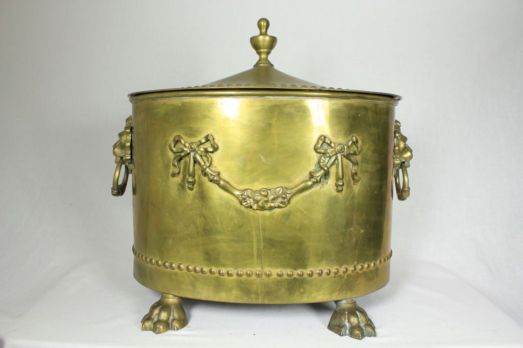 ANTIQUE VICTORIAN BRASS COAL BIN WITH LID AND HANDLES LION CREST. Wonderfully decorated coal bin features lion masked handles on both sides with four paw feet; rivet details along the circumference. A removable tin liner is inside of it. Can be used