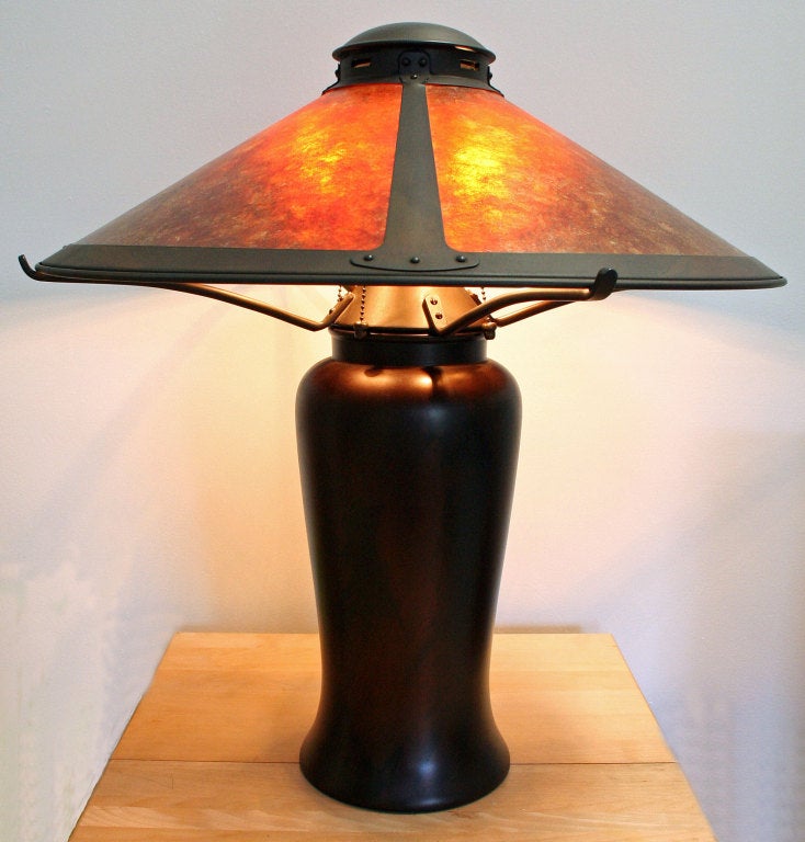 Of contemporary manufacture, this lamp, with its' elegant, yet subdued rich earth tones in mixed metals, gives a warm light through the amber-toned mica shade.