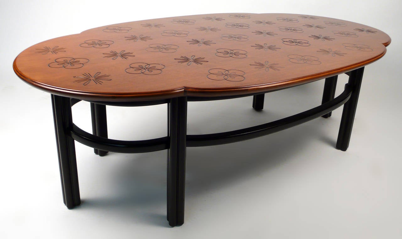 Walnut Baker coffee table with incised designs and dark mahogany base.
