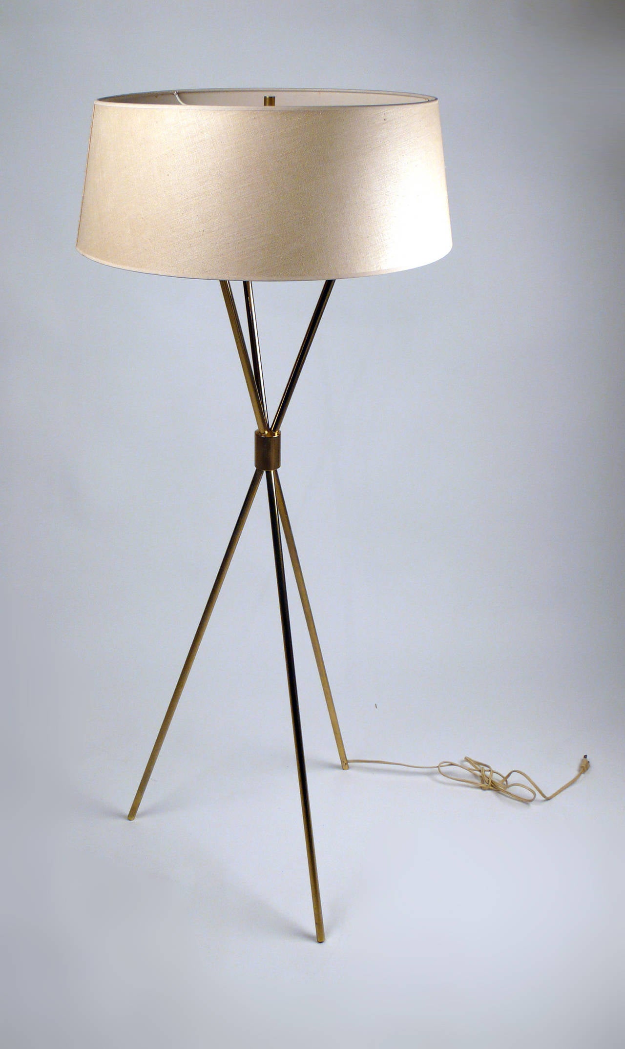 Early 1950s brass tripod floor lamp by T.H. Robsjohn-Gibbings for Hansen retains the original shade and functions as intended.