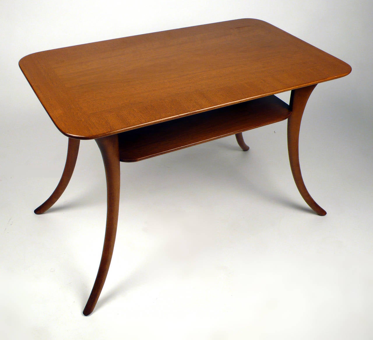 Elegant two-tier table by T.H. Robsjohn-Gibbings for Widdicomb in the original sherry finished Mahogany.