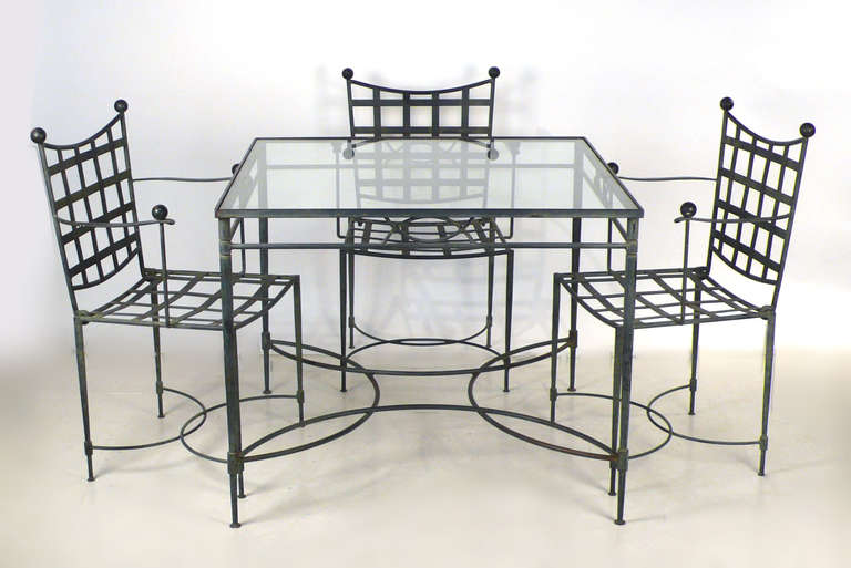Classic 1960's Salterini lattice back iron table and four chairs with ball finials designed by Mario Papperzini. This is a versatile set and it can be used indoors or outdoors. This sculptural design was used by Yves Saint Laurent in his personal