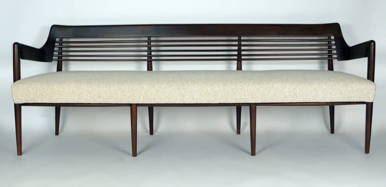 Italian walnut bench attributed to Dassi. The gracefully sculptural curves, elegantly tapering legs and pierced arms are all characteristic of the work of Dassi. Conceived in a similar language to the work of Ico Parisi and Paolo Buffa. The seat is