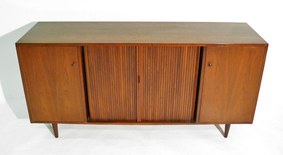 Tambour door credenza designed by Milo Baughman for Glenn of California. Tambours open to reveal four lacquered utility drawers. Both doors conceal an adjustable shelf. A nice modern designed utilitarian cabinet.