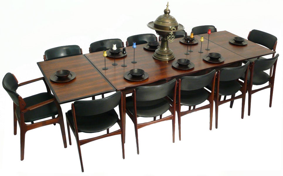 This is a spectacular set of 12 solid rosewood Erik Buck Dining Chairs and includes a stunning J.L. Moller Dining table and two leaves. The skirt, legs and framing of the table are crafted from solid brazilian rosewood and the top has an amazing