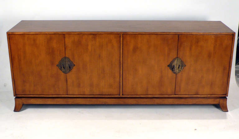 Renzo Rutili for Johnson Furniture Mahogany credenza with decorative brass hardware. Doors on the left side open to reveal a bank of three drawers with ring pulls. The top drawer is nicely segmented and felt lined. A very clean design with a nod to