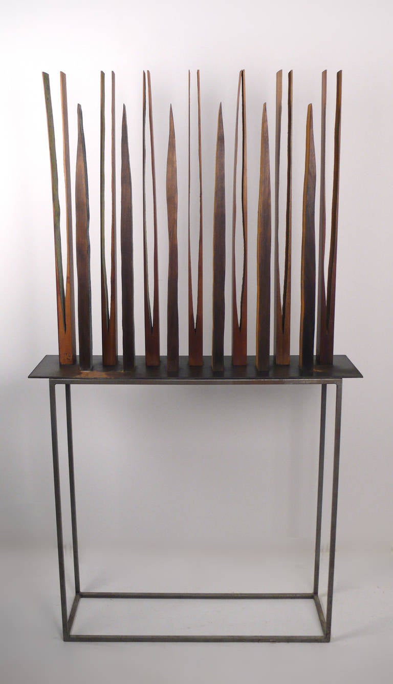 Asian Mahogany sculpture by renowned French-American artist Pascal Pierme. When viewed from one side the inner recesses of the wood have been treated with a patinated finish that resembles galvanized steel and from the other side like oxidized