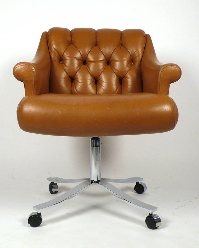 This deep tufted modernist desk chair is covered in a high grade cognac leather and shows just the right amount of wear. The castors could easily be replaced with glides if one preferred to use it as an occasional chair. Although we were unable to