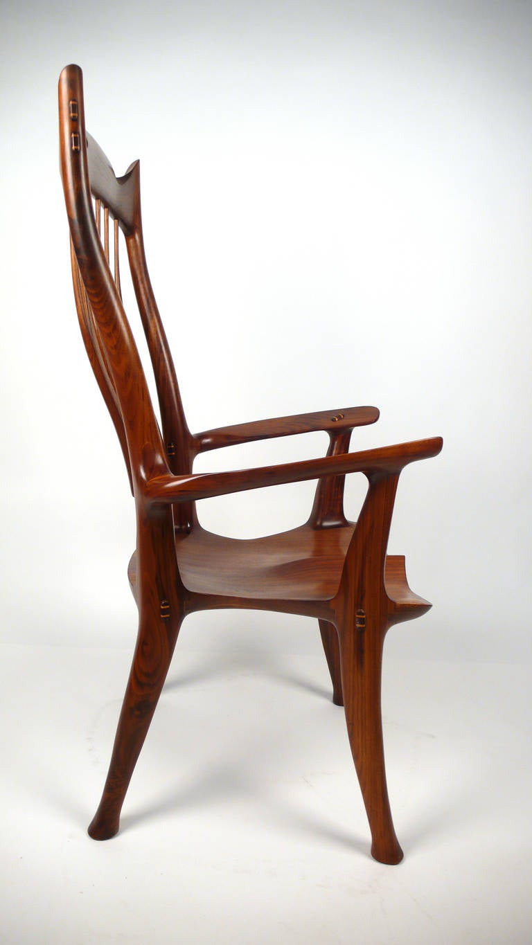 Hand-carved walnut arm chair designed and fabricated by David Hentzel who was an apprentice to Sam Maloof and worked in his studio for a time. Not a copy of Maloof, rather constructed in the in the same masterful language of Maloof but with its own