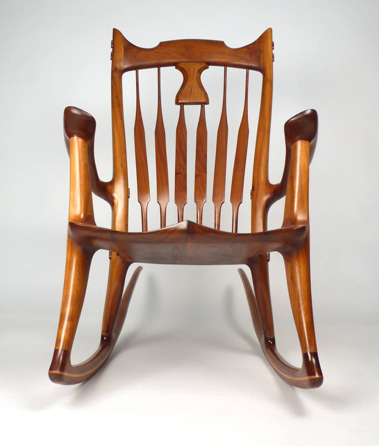 Hand carved walnut rocking chair designed and fabricated by David Hentzel who was an apprentice to Sam Maloof and worked in his studio for a time. Not a copy of Maloof, rather constructed in the in the same masterful language of Maloof but with its