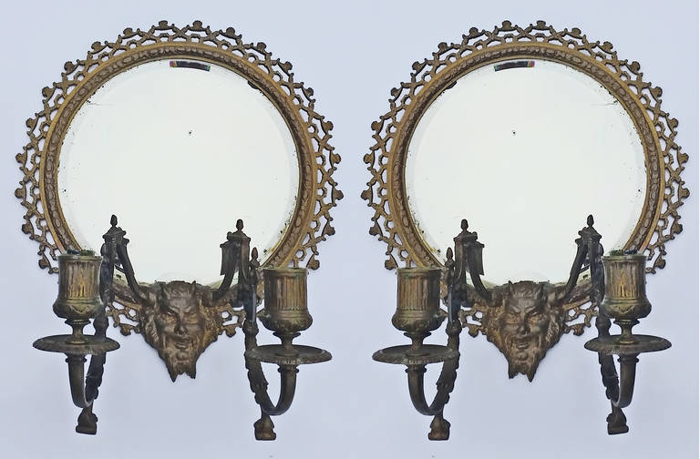 Striking pair of cast bronze frames with beveled mirrors by Tiffany and Co. featuring the head of a mythological creature, possibly a Satyr,  and two candle holders.