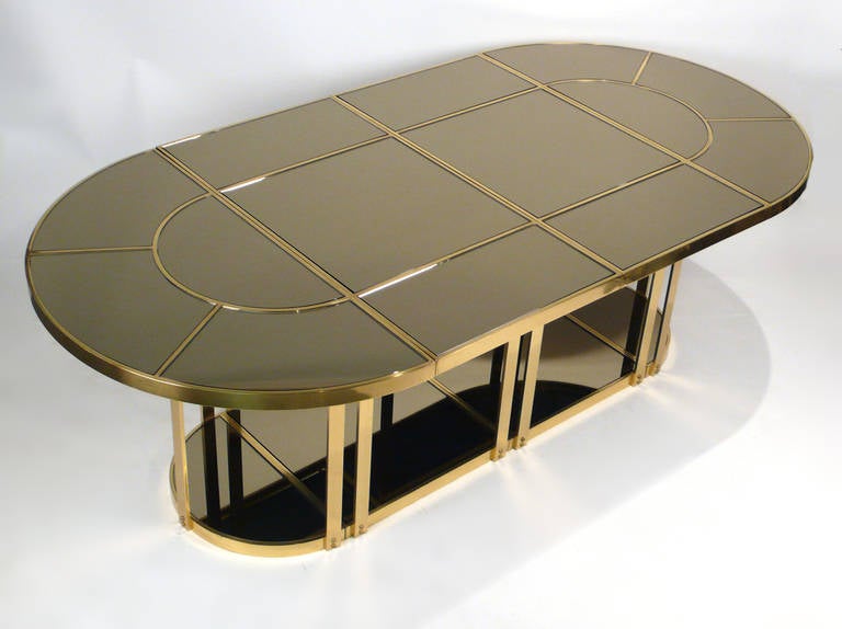 Milo Baughman Dining table consisting of a polished brass frame with inset bronze mirrored tops. The frame is comprised of four sections that disassemble for easy installation and transportation.