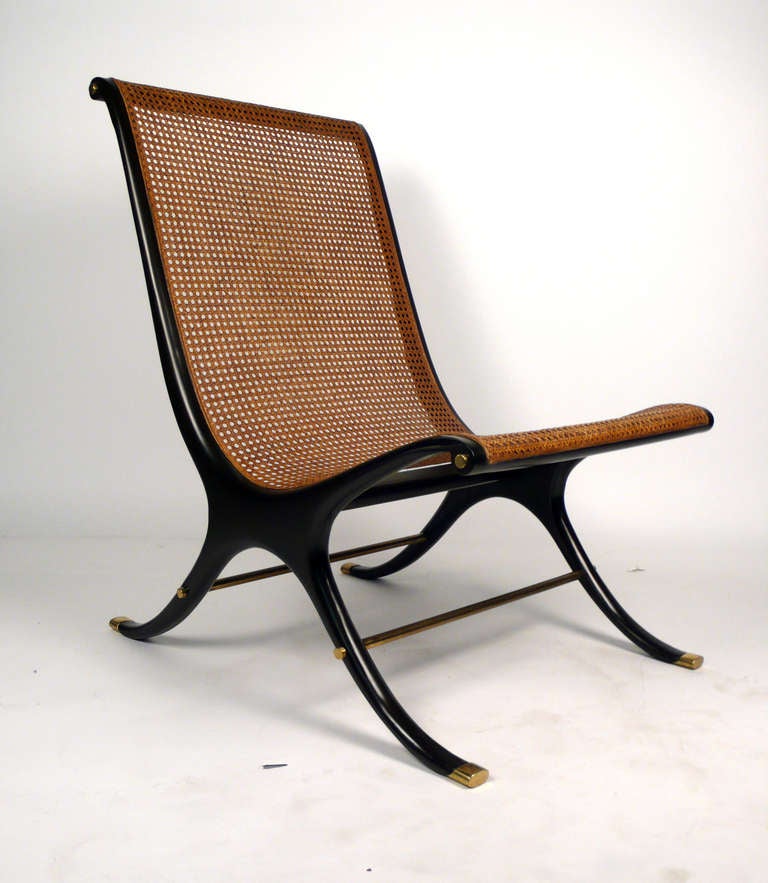 Lacquered wood brass and cane lounge chair by Gerald Jerome for heritage. This is an exquisite design from 1968 and is featured in the 