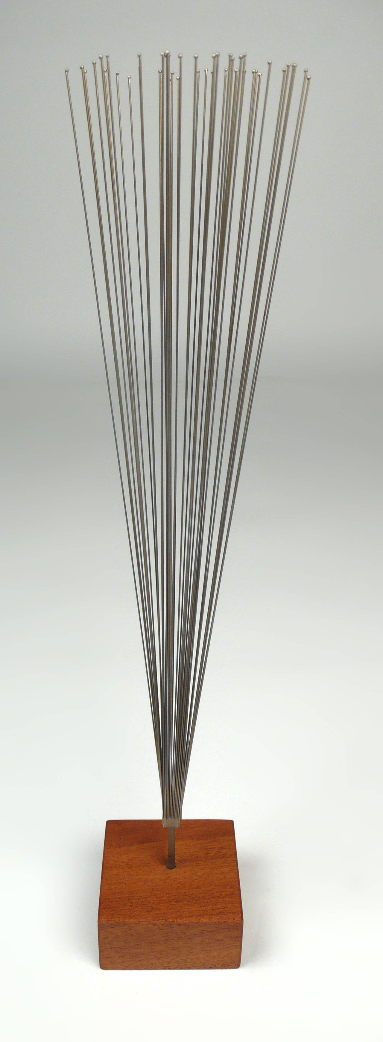 Stainless steel wires silvered in conical form to stainless steel stem and mounted to mahogany base. Sold with a title of authentication from Bertoia Studio.