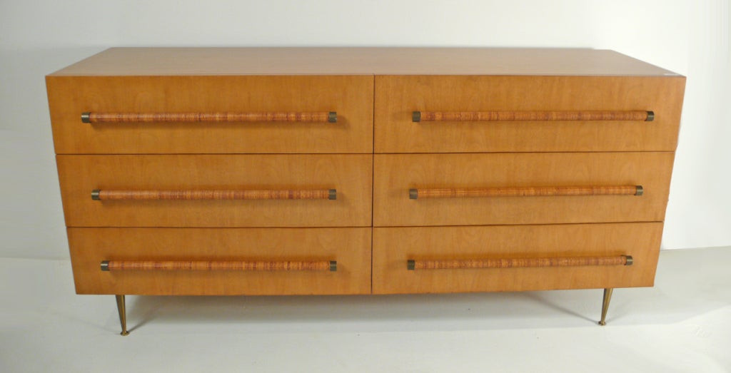 Six drawer dresser designed by T.H. Robsjohn Gibbings for Widdicomb. Tapered brass legs and woven cane wrapped handles with brass fittings.