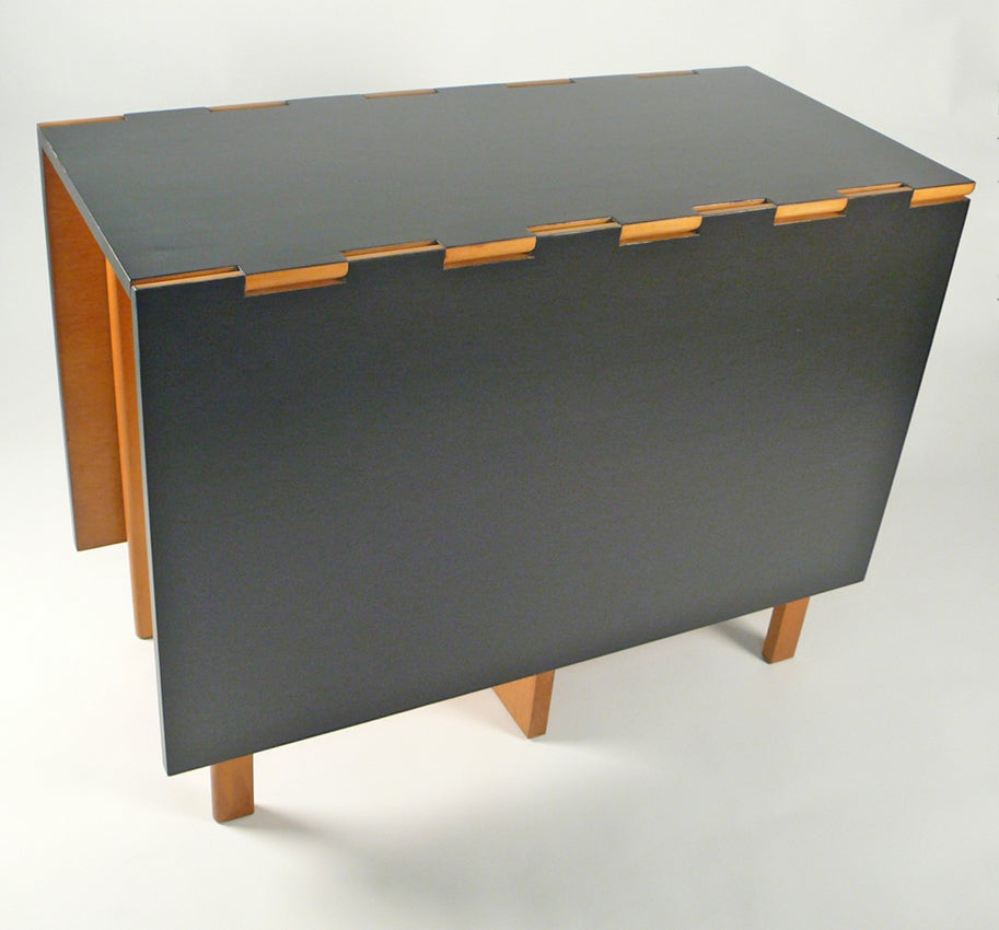 One of George Nelson's most complicated designs for Herman Miller the 4656 Gateleg Table is a modular masterpiece. This example is in the original primavera finish with a stunning refinished top executed in a black aniline dye with multiple coats of