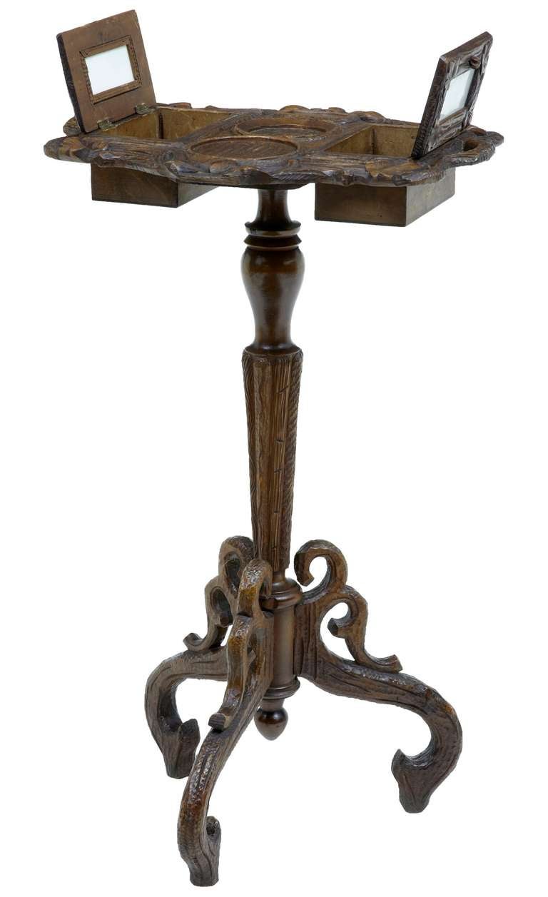 Here we have an unusual carved Black Forest tobacco mixing table, although we can't rule out it being a teapoy. Features 2 enclosed boxes, to which there is space to put labels under the doors. 

Carved stem, standing on carved tripod legs.