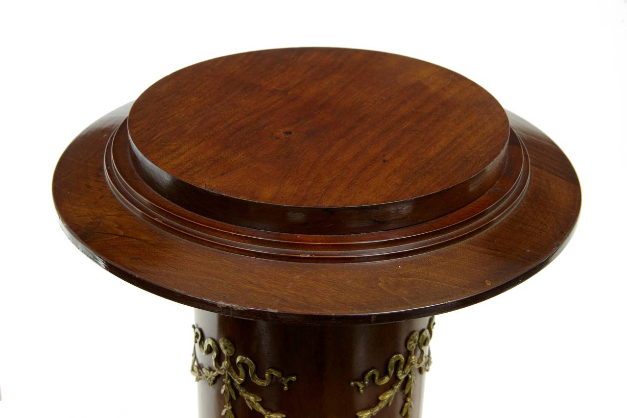Empire influenced mahogany pedestal, with ormolu decoration, circa 1900. 

Measures: Top diameter 8 3/4