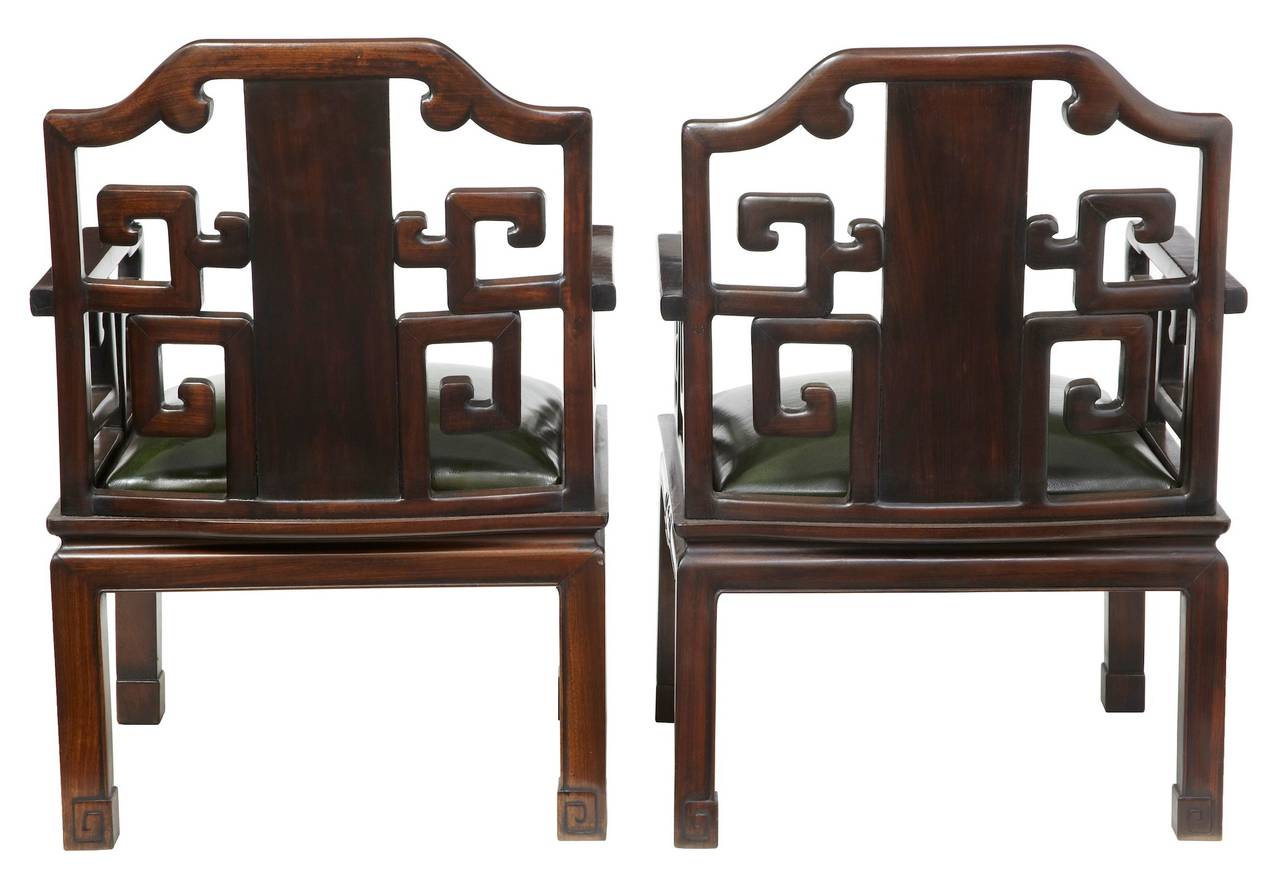 Pair of Chinese rosewood armchairs circa 1900. 

With later green leather seats