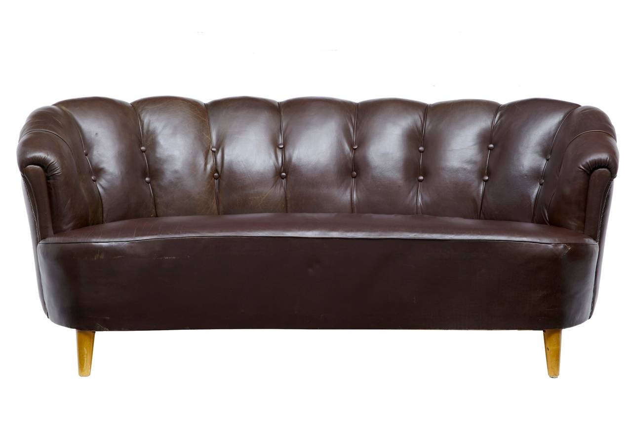Brown leather suite very much in the Art Deco taste, circa 1970.

Shell backs, stud work on the arms. 

Sofa measurements: 

Height 30