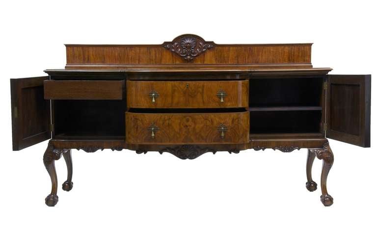 HERE WE HAVE A STUNNING SIDEBOARD, SUPERB QUALITY VENEERS. 

SIDEBOARD COMPRISES OF 2 DEEP DRAWERS TO THE CENTRE AND A CUPBOARD EACH SIDE, ONE FITTED WITH A SHELF AND THE OTHER WITH A FITTED CUTLERY DRAWER. 

CARVED SHELLS AND FOLIAGE TO