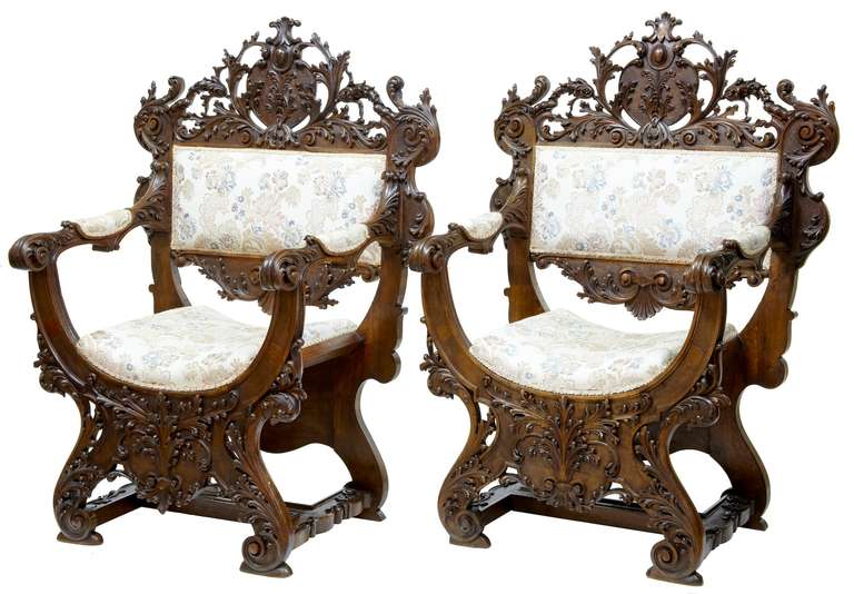 Here we have a pair of Italian Savonarola armchairs which are of the finest quality we have ever seen.

Profusely carved in walnut all-over. Pierced ornate carving to the back and pierced carved florals and swags joining the arm to the