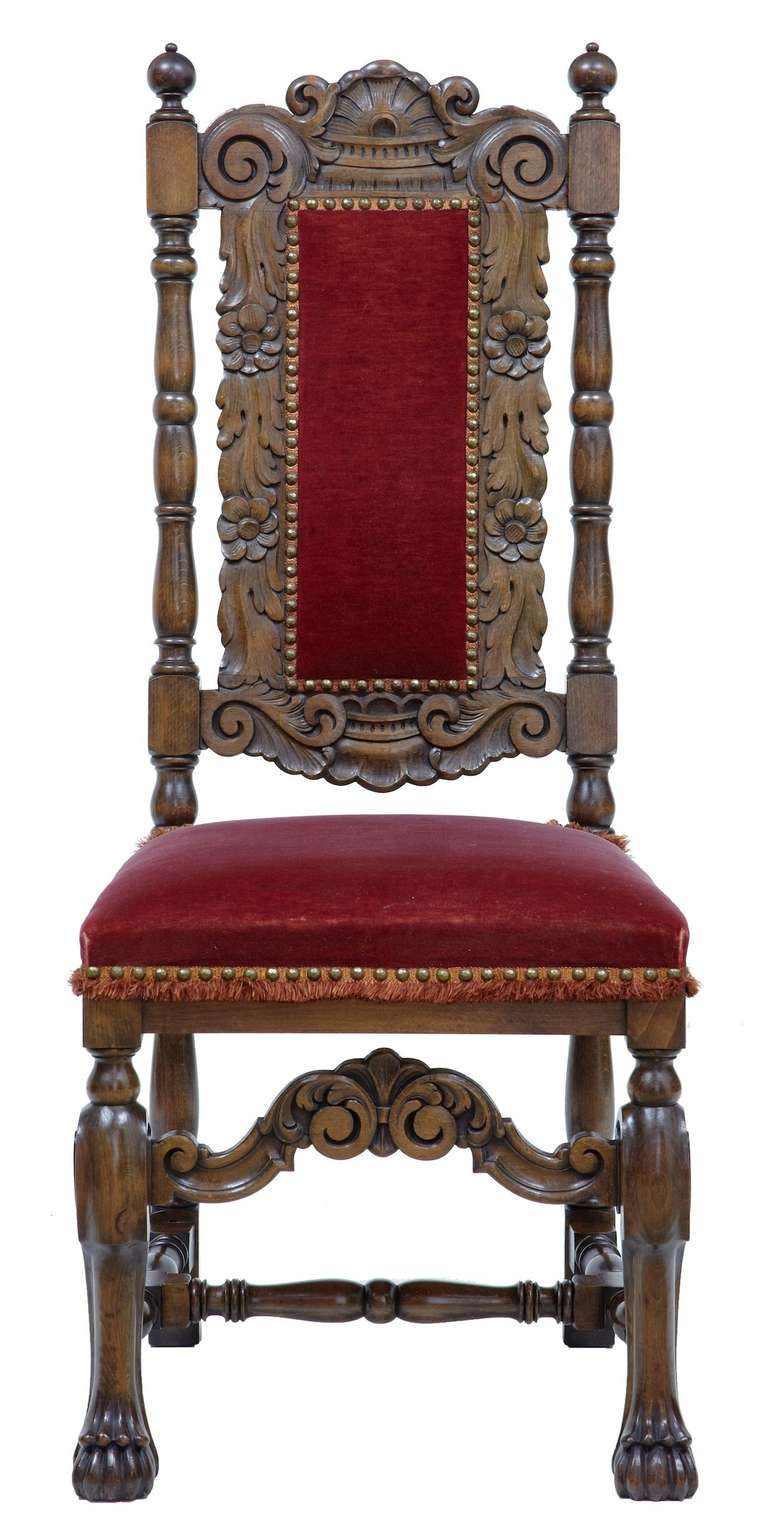 Swedish made set of 6 carved dining chairs circa 1920's. 

Oak in color, these chairs are very well carved in the baroque style. 

Upholstered in plush red velvet and tassel trim.