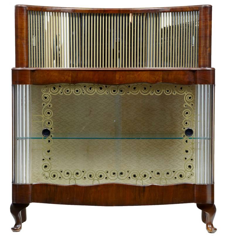Art Deco influenced drinks cabinet, circa 1950. 

Mirrored two-door bottle section, painted glass sliding doors with single shelf below.

Height: 47