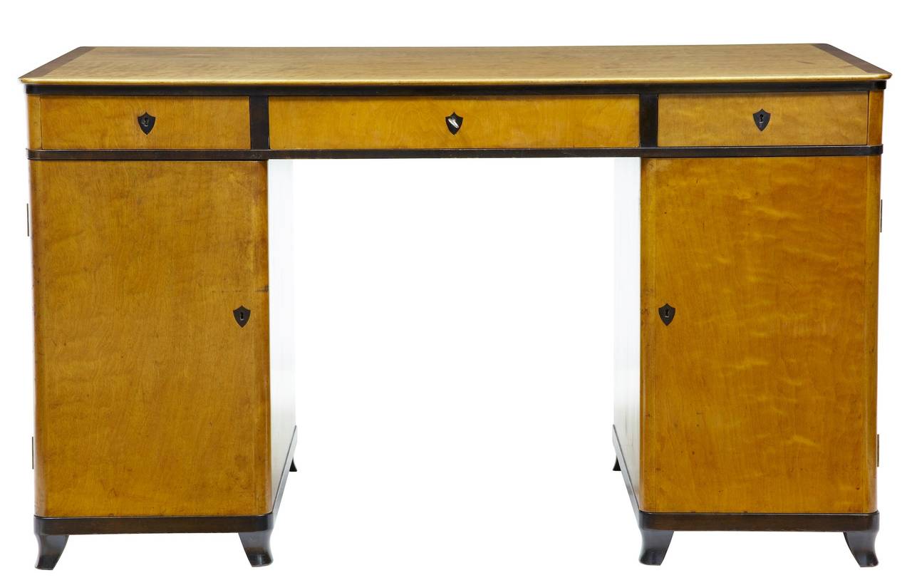 Beautiful period art deco birch desk circa 1920. 

Stamped by the reknowned department store a.B nordiska kompaniet stockholm. 

Beautiful rich birch desk with ebonised edging to drawer fronts, feet and shield shape estcheons. 

Pedestal desk