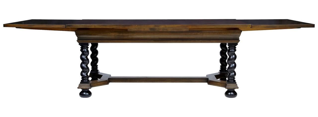 Large extending swedish dining table circa 1920. 

Made in the jacobean taste, walnut veneered top to main piece with birch draw leafs. 

Ebonised barley twist legs and feet, united by y frame stretcher.

HEIGHT: 30