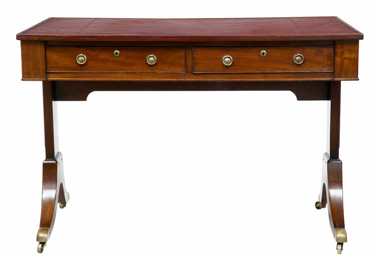 Mahogany writing table circa 1880 with later legs. 

2 drawers either side, original red leather top with gold tooling. 

Standing on brass castors.

Marks and scuffing to leather top.

Height: 31 1/2