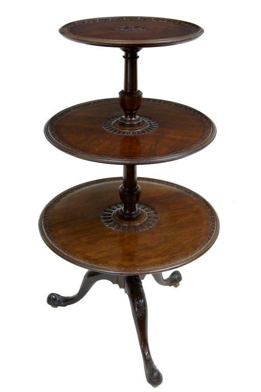 Nicely carved three-tier mahogany dumb waiter standing on carved stylised snailed feet on brass castors.

Measures: Height 42