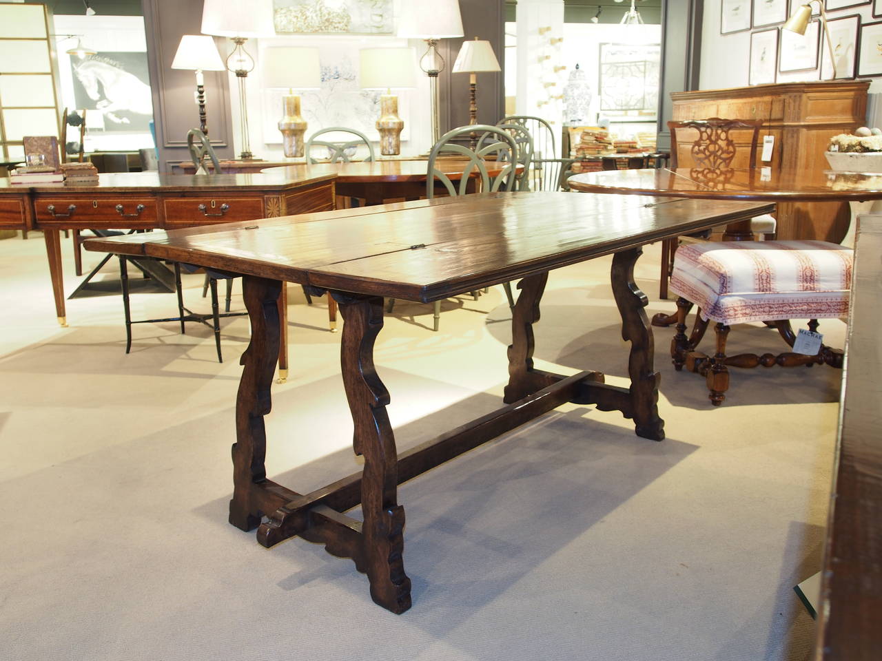 Spanish solid oak table with drawer. This table has folding leaves that open up to create a larger table. Lyre shaped carved legs with an oak stretcher. Measures: 21