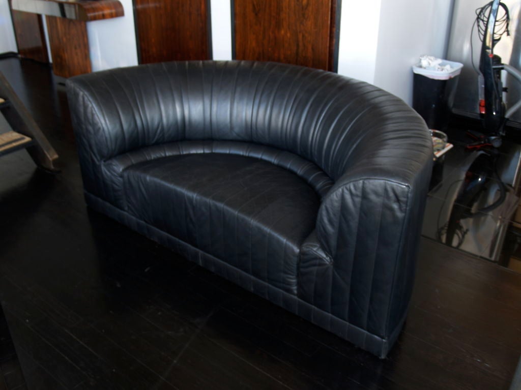 a great love seat in black leather.<br />
it is a half moon shape, sleek and modern.<br />
the condition is very good.<br />
a perfect size for that small space that needs the that custom size fit.