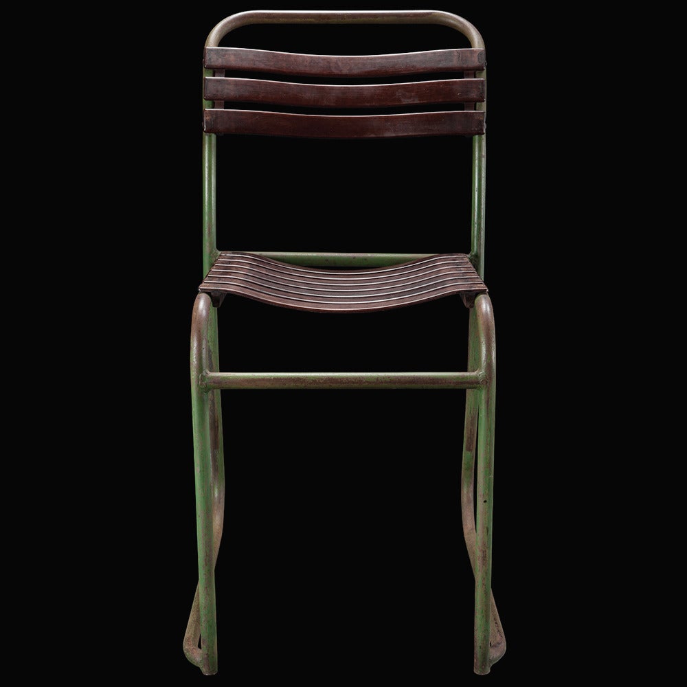 Brown slatted bakelite seat and back, on weathered green iron base. 

Manufactured in France, circa 1940