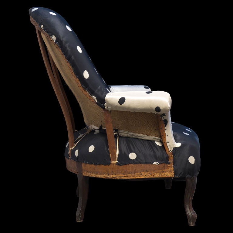 Simple roll arm primitive sitting chair with black and white polka dot fabric.