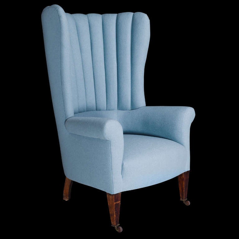 Newly upholstered in blue wool fabric, with original brass casters.