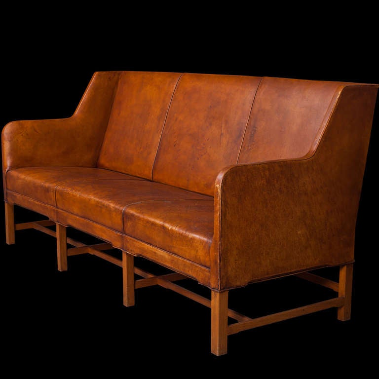 Model 4118, three-seat sofa with original Niger leather on European cherry stretchers, finished with fitted brass nails. 

Designed by Kaare Klint and manufactured by Rud. Rasmussen in Denmark.