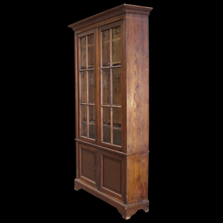 Tall pine storage cabinet with original glass, wood shelves, and two storage areas below